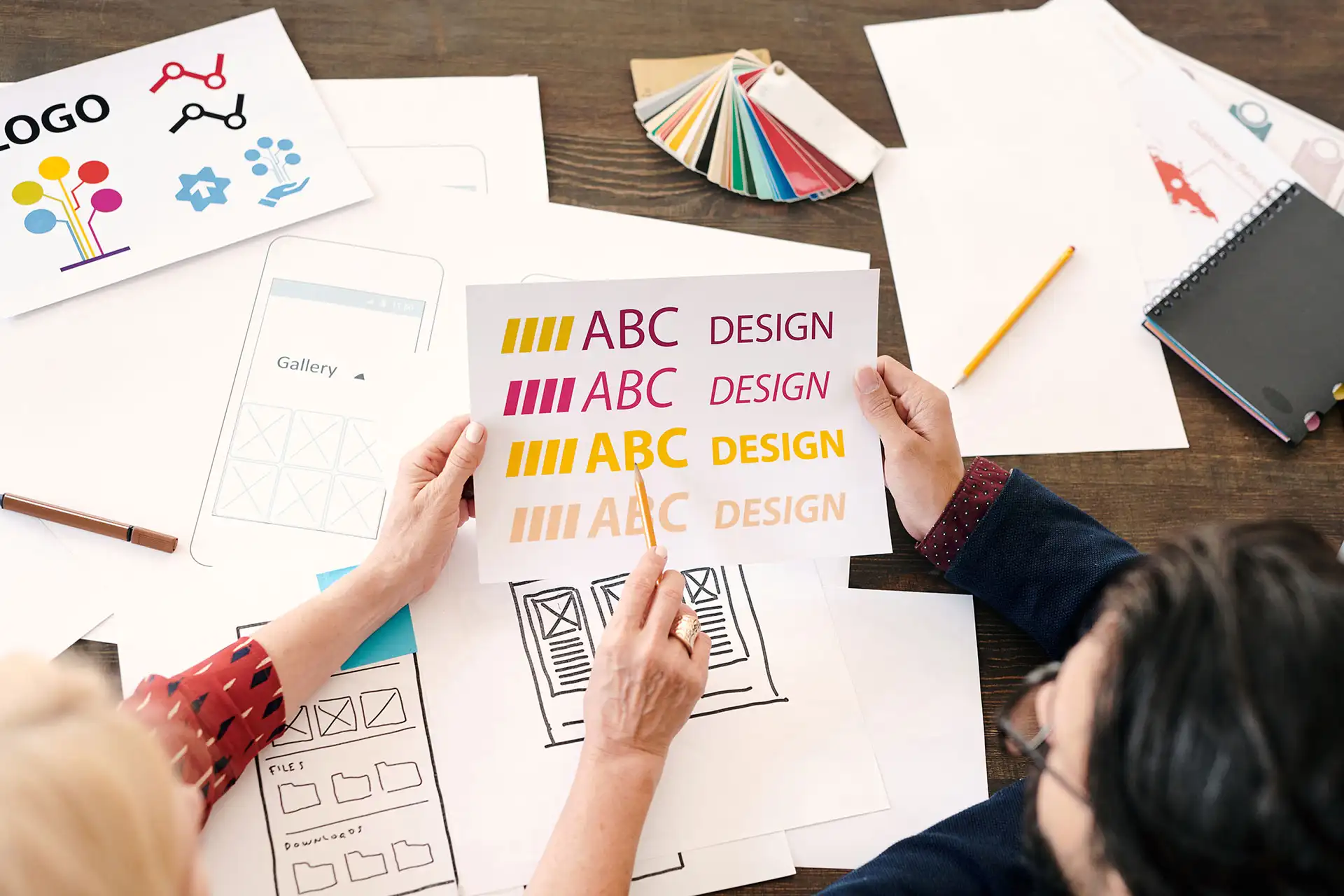 Kurumsal web tasarımı için renk ve tipografi seçenekleri üzerinde çalışan iki tasarımcı